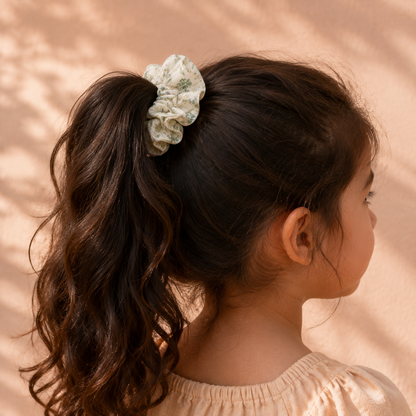 Child wearing the Green Meadow green botanical cotton scrunchie in a ponytail