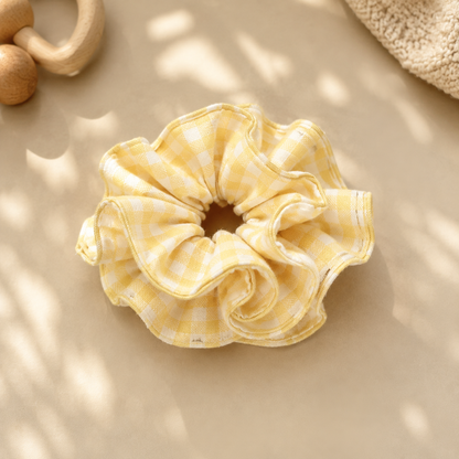 Butter Gingham yellow and white ruffle cotton scrunchie displayed in warm natural light with a wooden baby toy